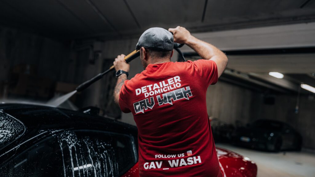 Antonio, proprietario e detailer a domicilio Gav Wash, ritratto con logo sulla schiena